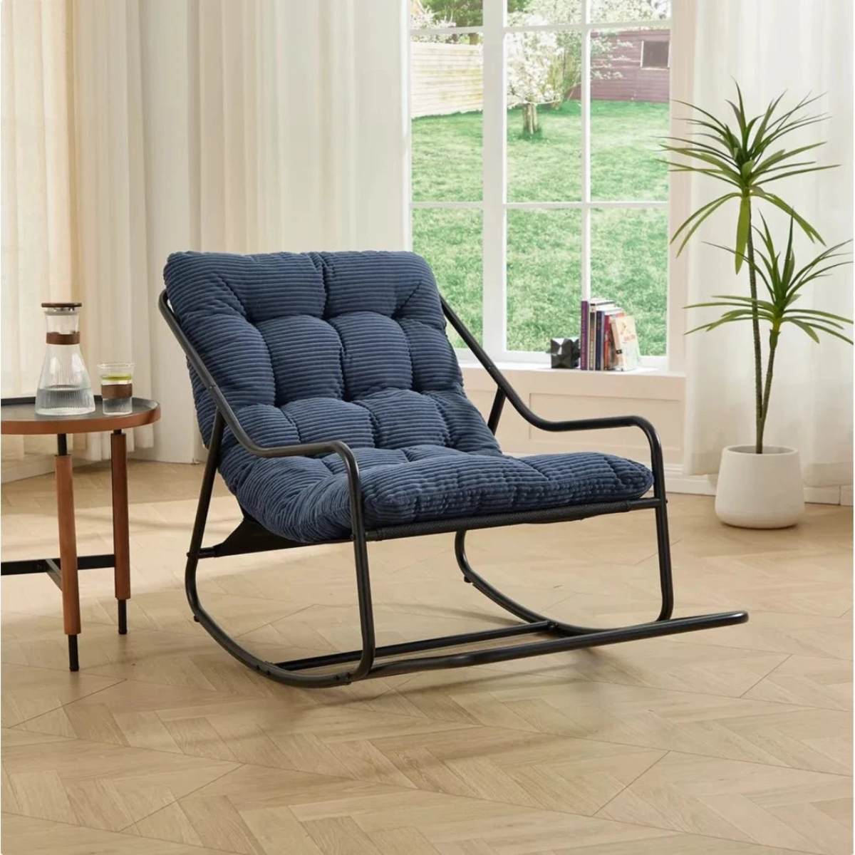 Blue cushioned rocking chair in a room with a window and plant