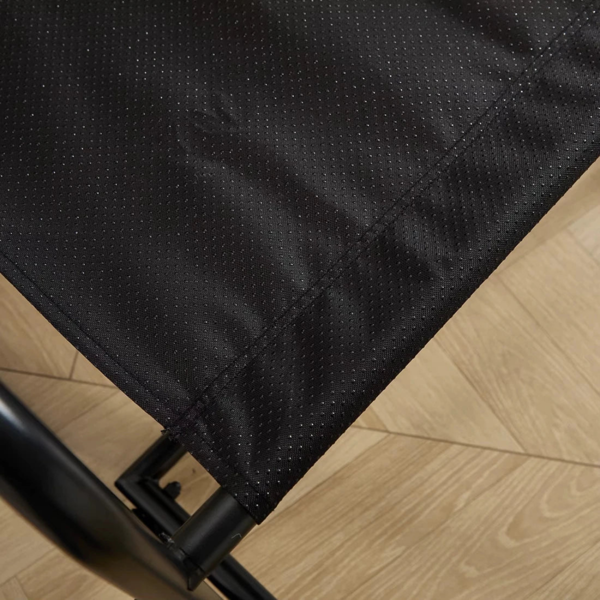 Close-up of a black fabric surface on a wooden floor