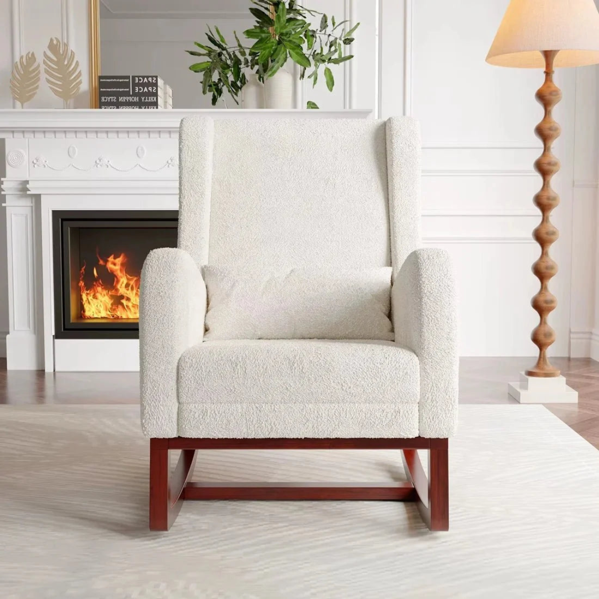 White armchair in a living room with a fireplace and lamp.