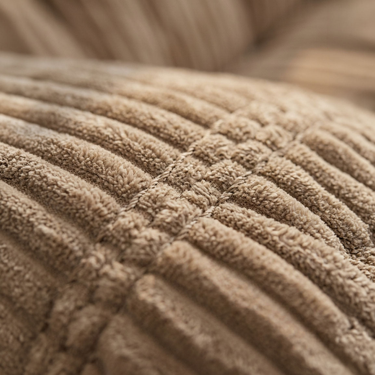 Close-up of a ribbed corduroy fabric in a warm taupe-brown color, showing the textured vertical channels and stitched details.