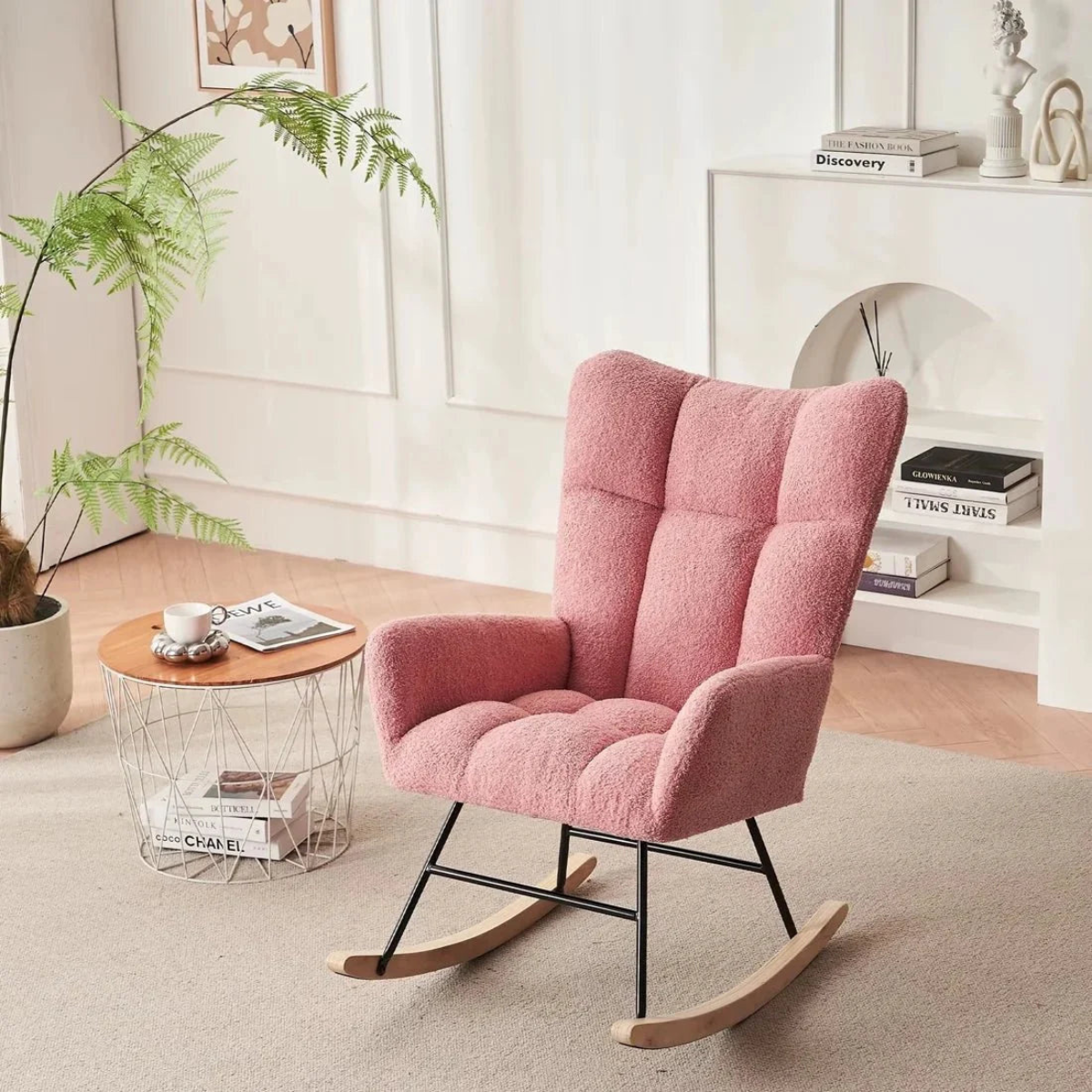 Pink rocking chair in a cozy living room with a small table and plant.