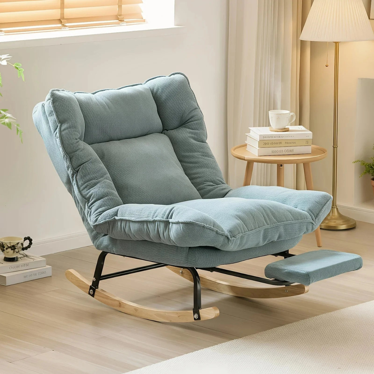 Blue rocking chair in a cozy living room setting with a side table and lamp.