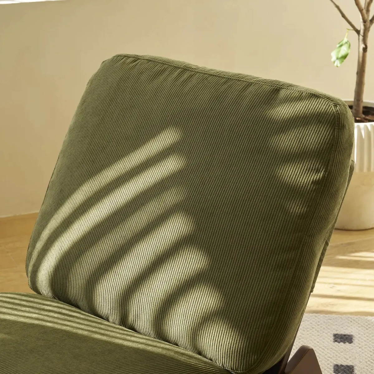Green cushion on a chair with sunlight casting shadows