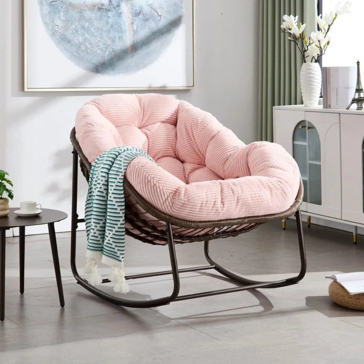 Pink cushioned chair with a striped blanket in a modern living room.