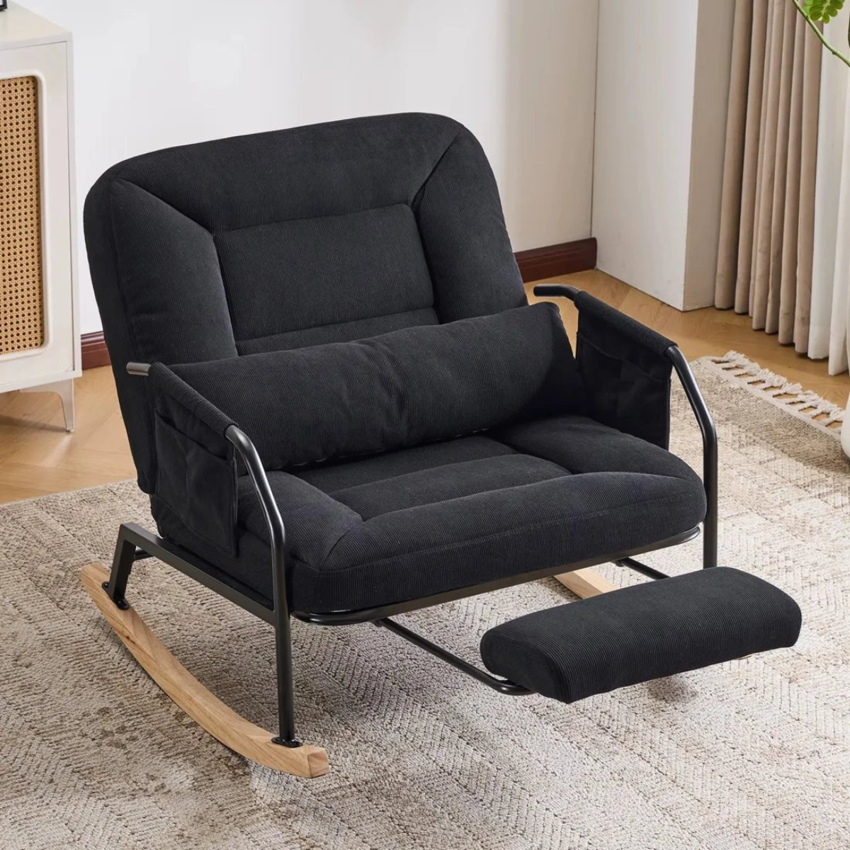 Black rocking chair with footrest in a room setting