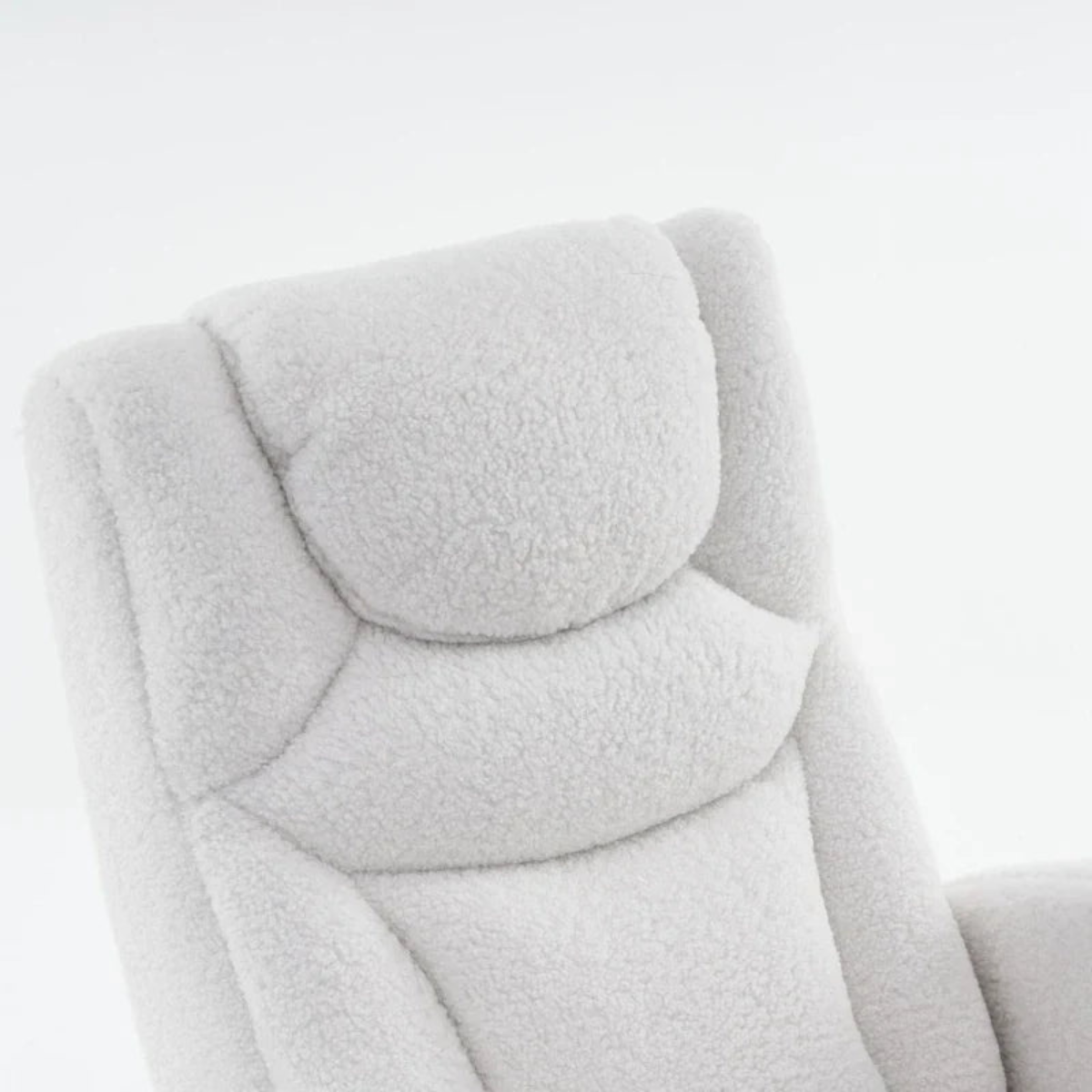 Close-up of a plush, high-back armchair upholstered in a soft, textured bouclé fabric in a very light gray or off-white color, set against a seamless white background.