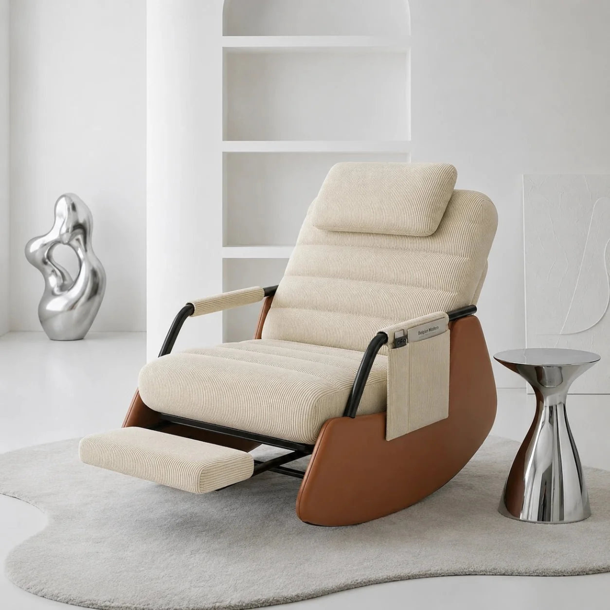A modern rocking recliner chair with cream textured upholstery and a brown wooden base, styled in a minimalist white room with a small metallic side table and abstract sculpture.