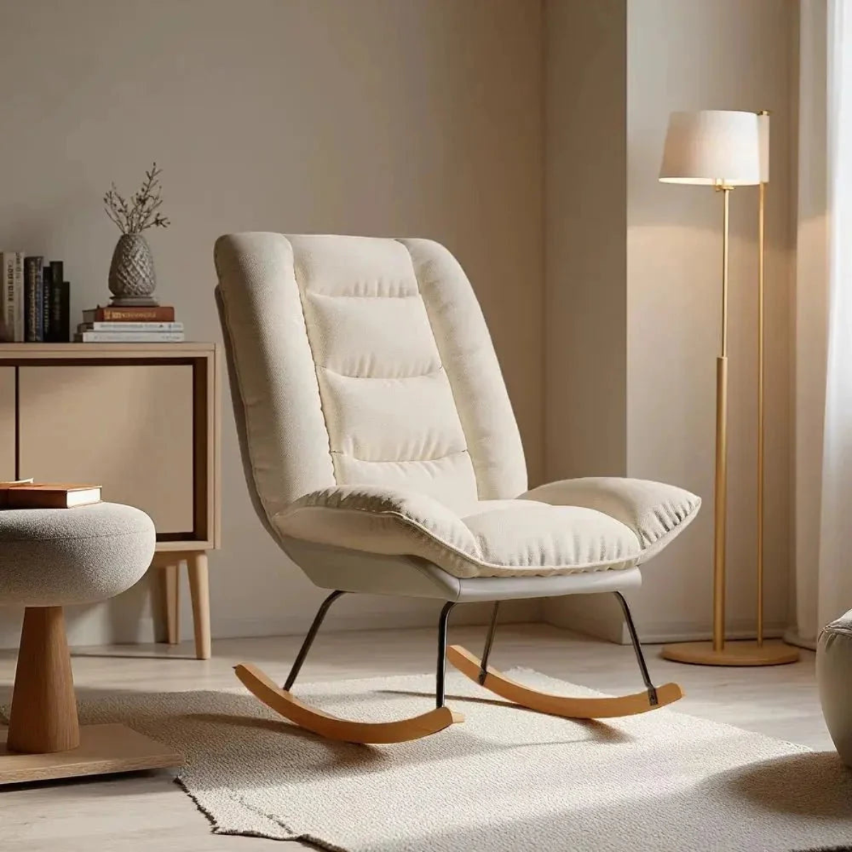 Beige rocking chair in a cozy room with a lamp and books.