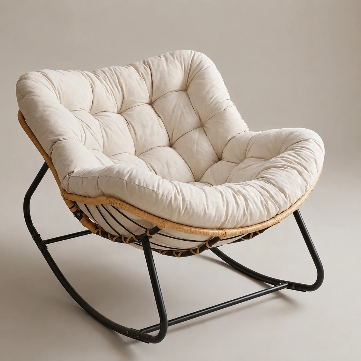 Rattan rocking chair with a large cushion on a plain background