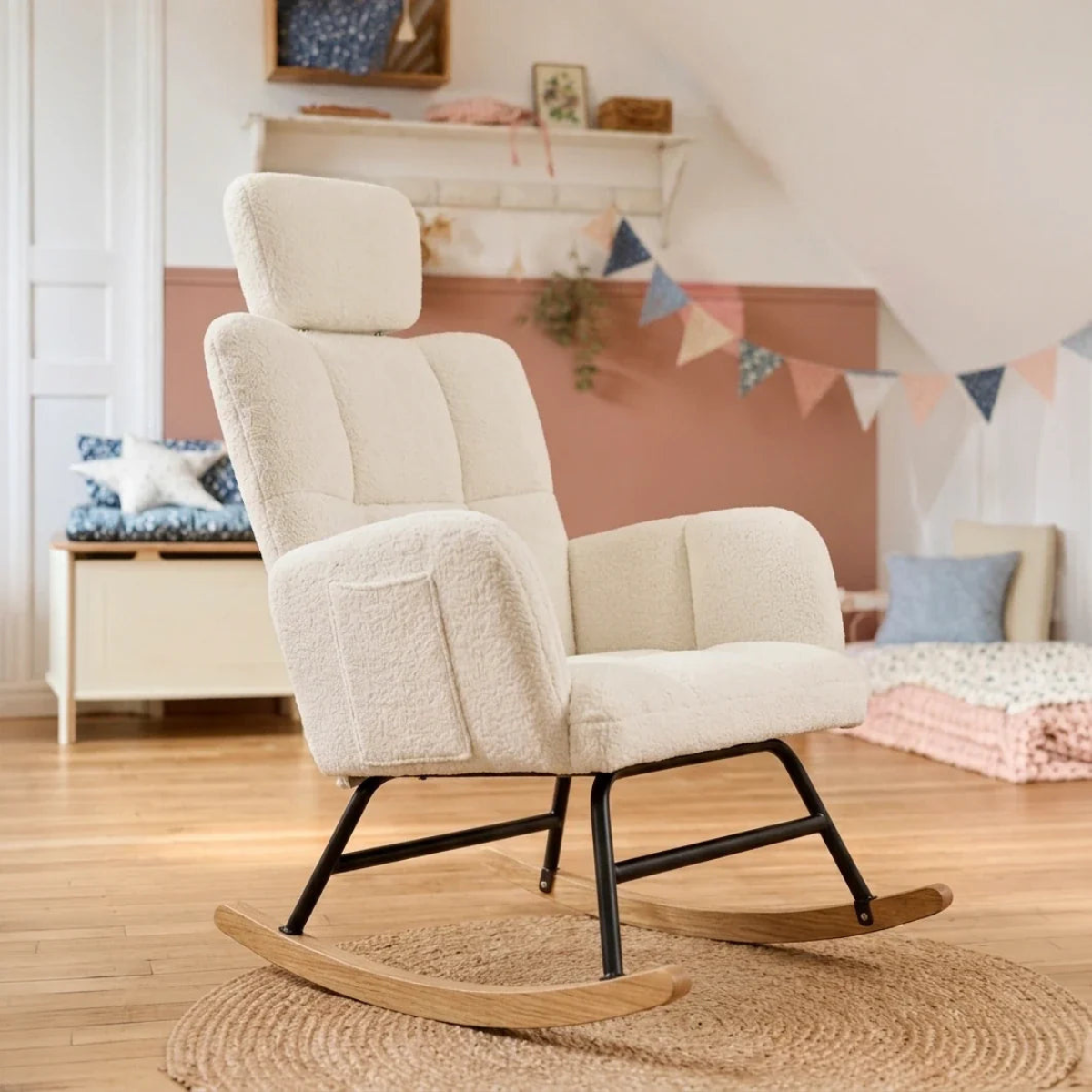 Cream bouclé rocking chair with a black metal frame and wooden rockers, placed on a woven rug in a softly decorated nursery or playroom.